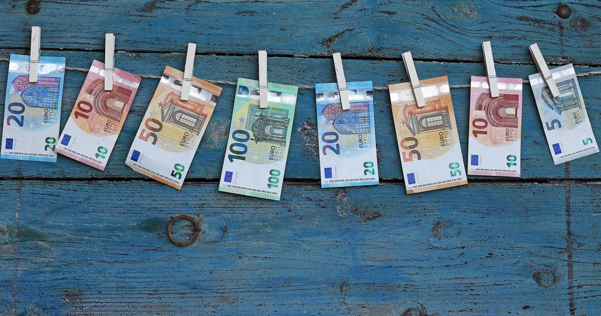 Verschillende euro biljetten hangen aan een waslijn met wasknijpers